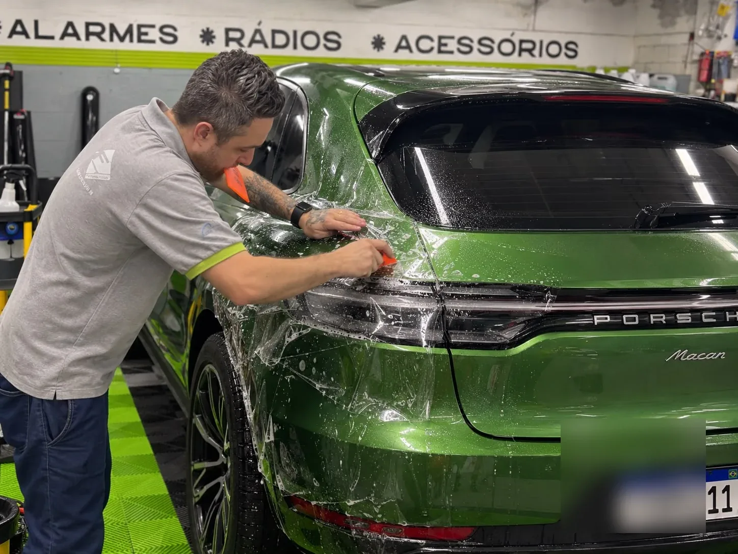 Aplicação real de PPF em um Porsche verde na Thunder Som, com placa desfocada